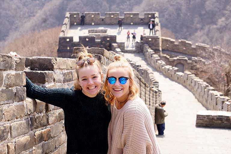 Two students stand on the Great Wall of China.