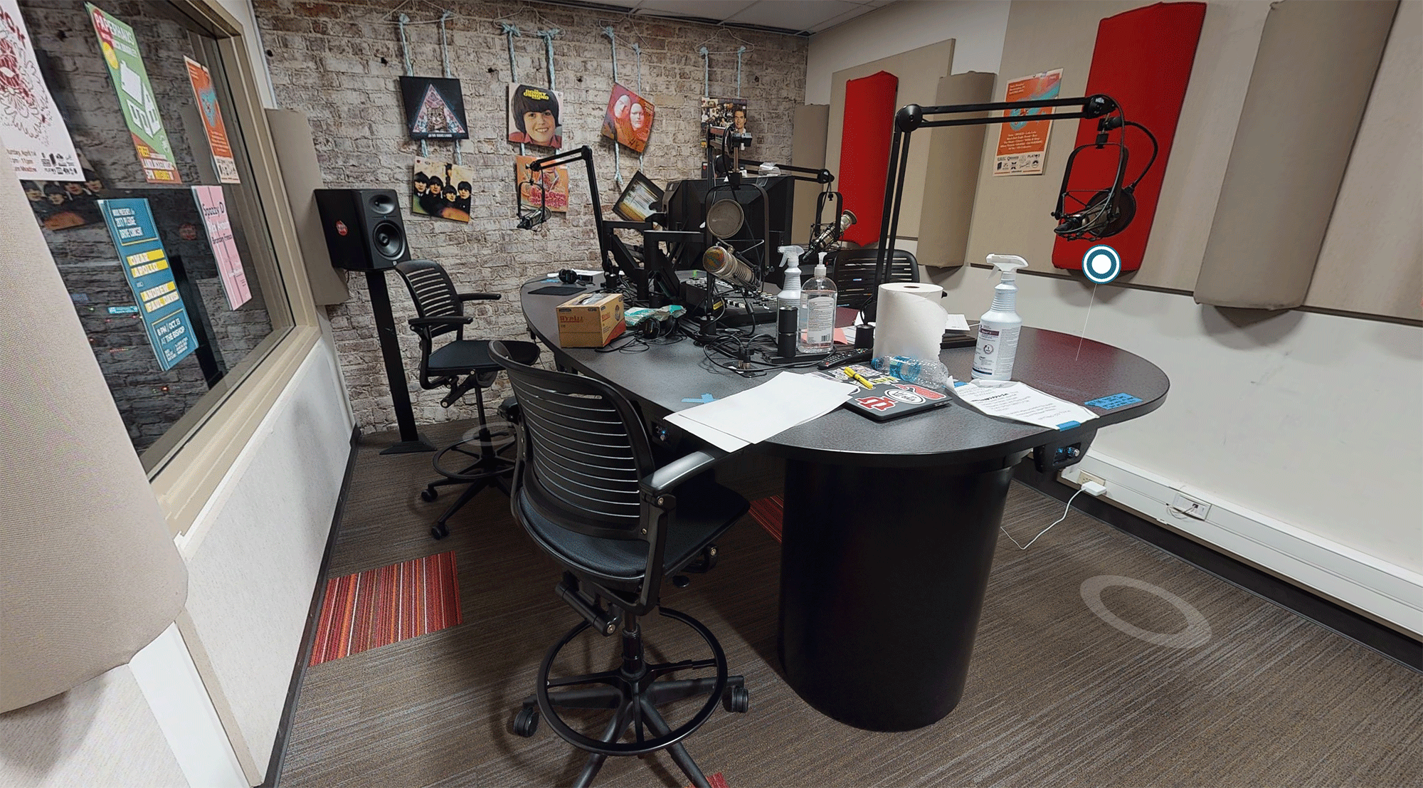 Photograph of the WIUX radio station studio with a large black desk and recording equipment.
