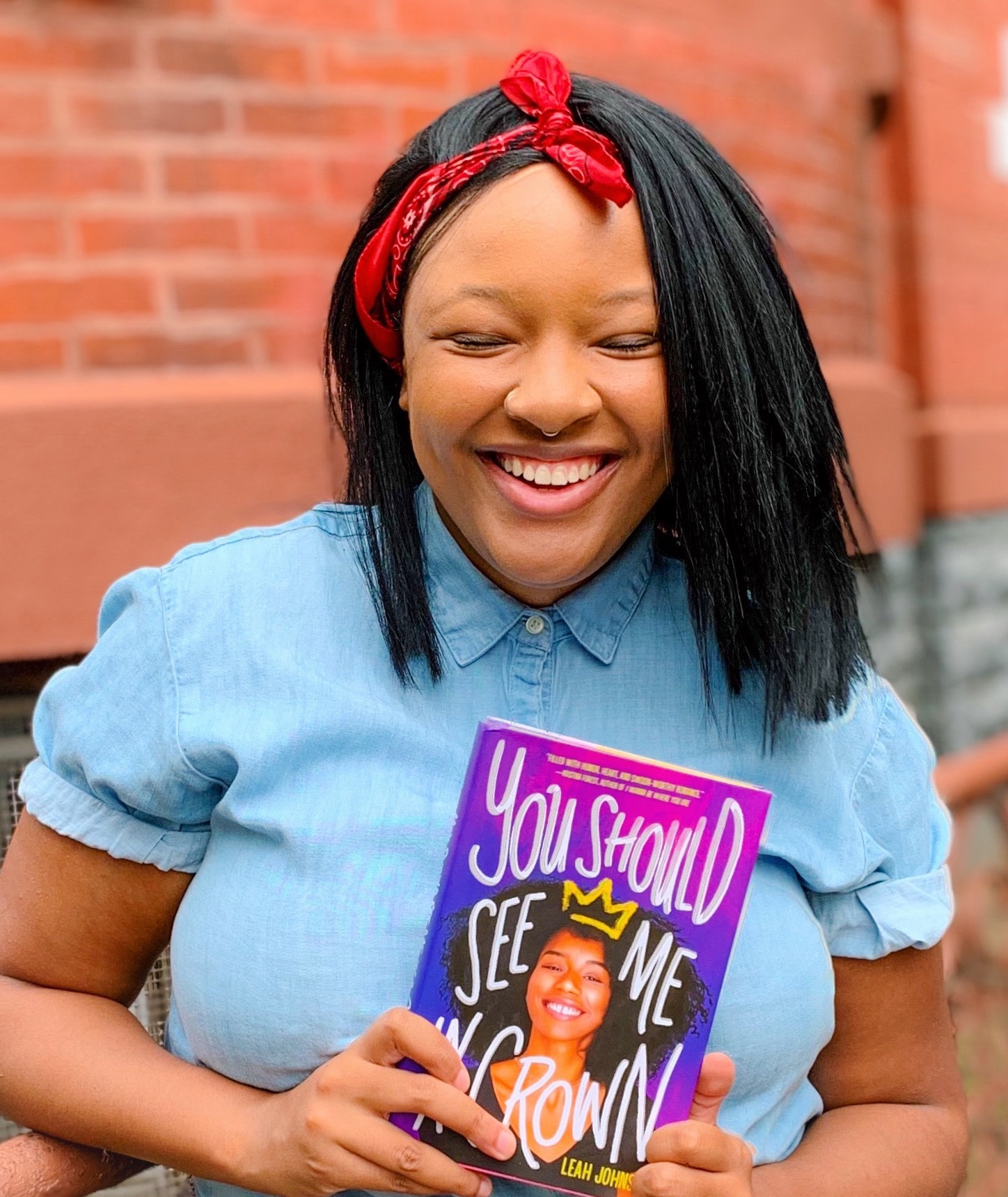 Leah Johnson holding the book "You Should See Me in a Crown"