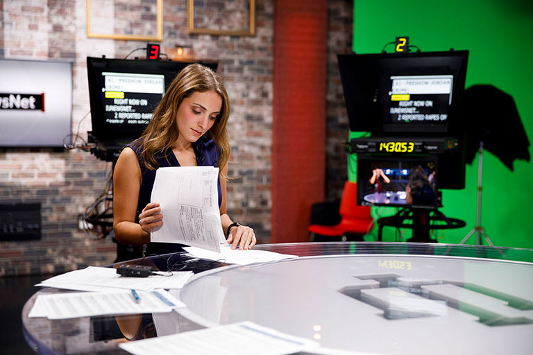 A student at a news anchor desk.