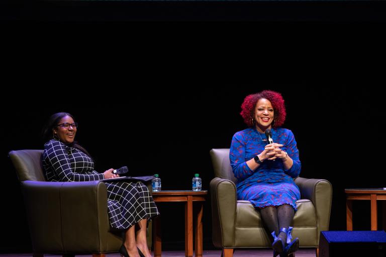 Speaker Nikole Hannah-Jones sits wearing a blue dress on stage at the Lou Mervis Distinguished Lecture at the IU Auditorium on Oct. 20, 2022. 