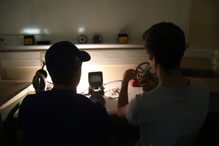 Two students work manually with film. 
