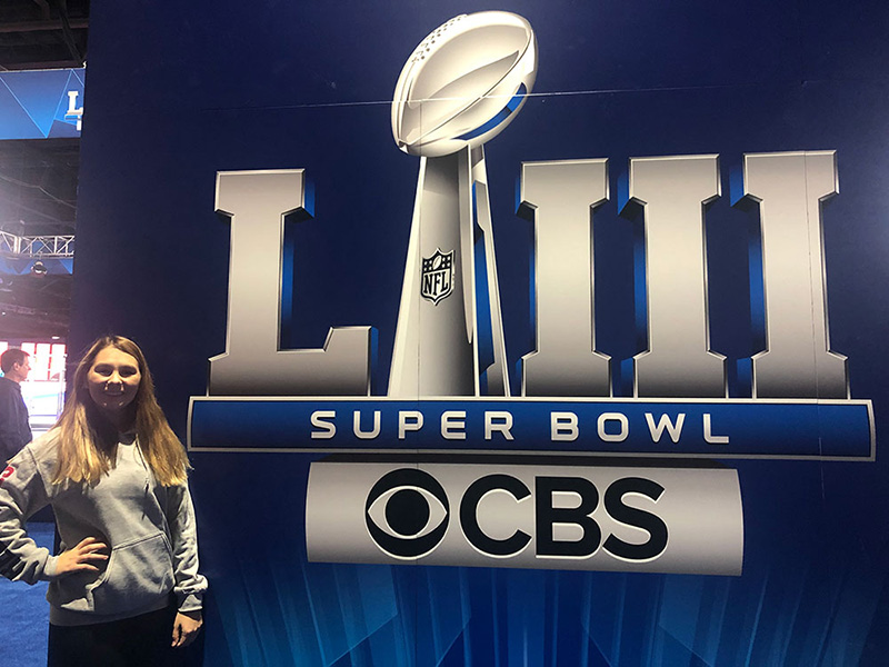 A student stands next to the Super Bowl CBS sign in Atlanta.
