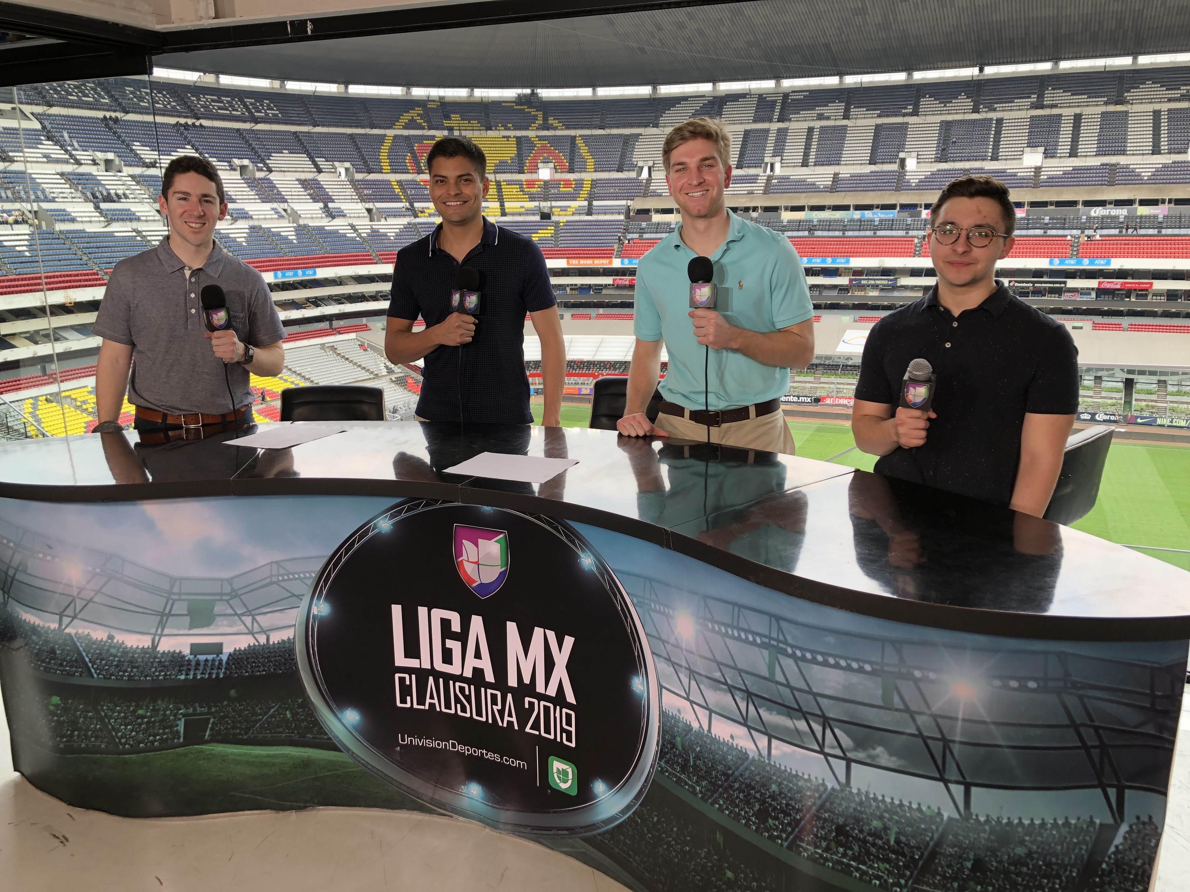 Students hold microphones to broadcast from a soccer stadium in Mexico.