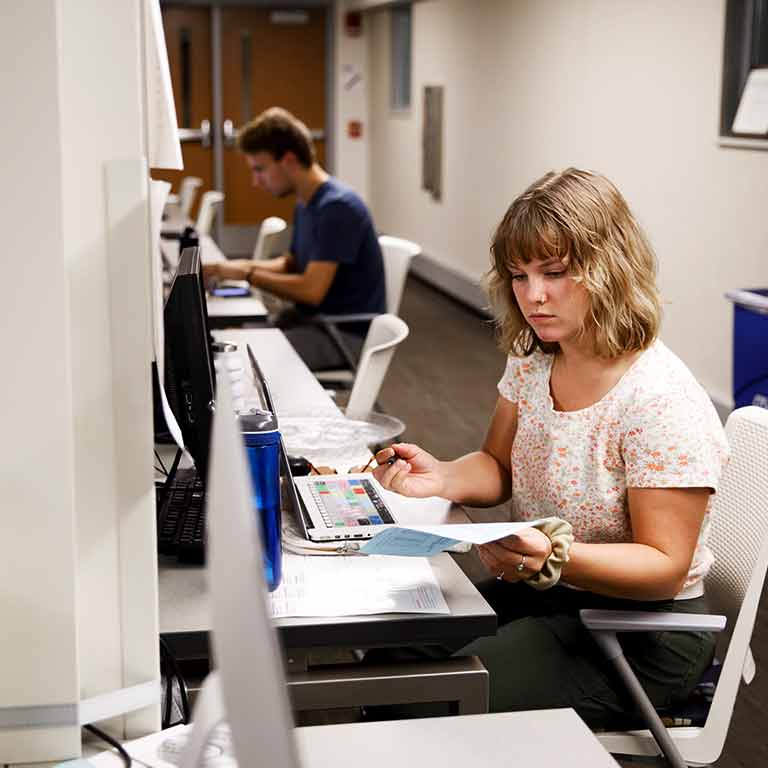 A student works on their research in a computer lab.