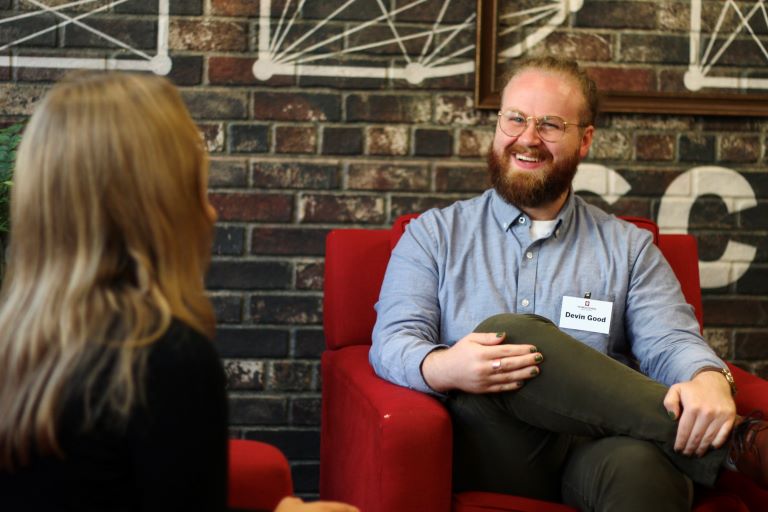 Person smiles at another while they are both seated talking to one another during an inverview.