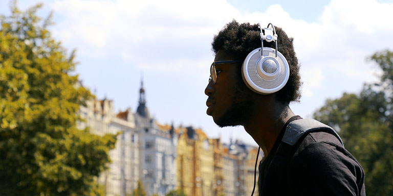 A student wears headphones outdoors.