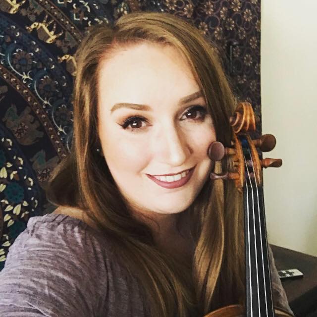 Headshot of Kari Krafft holding up a violin.