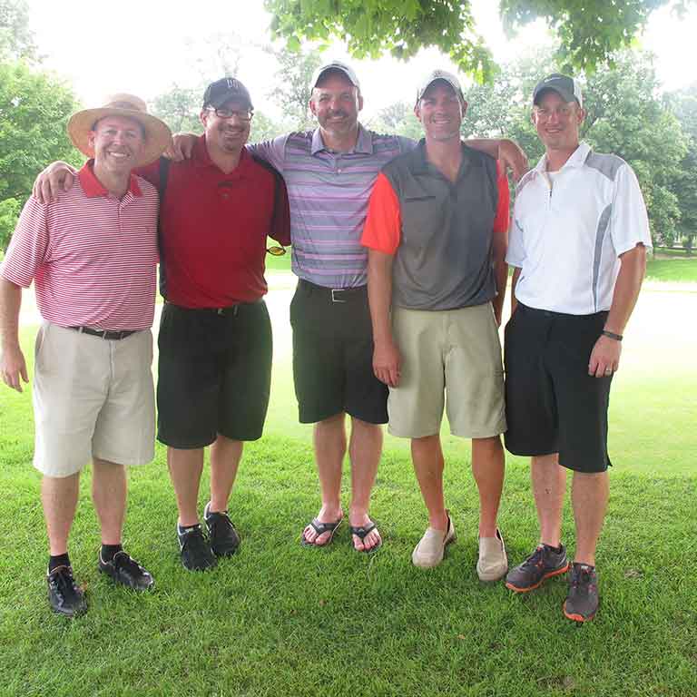 John Jackson playing golf with four other men