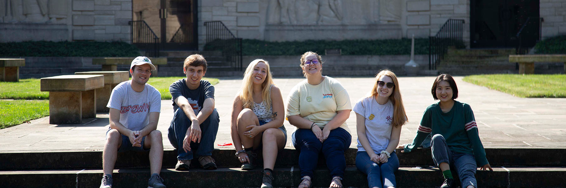 A group of students sits on a short outdoor staircase.